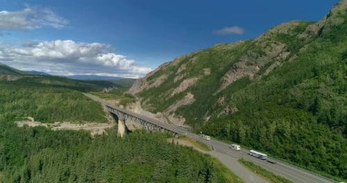 Drone View of Three White RVs Crossing Alaskan Mountain Viaduct Over the River