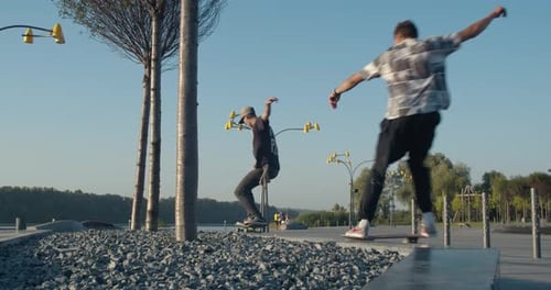 Skateboarders Performing Tricks in Urban Park on Sunny Day