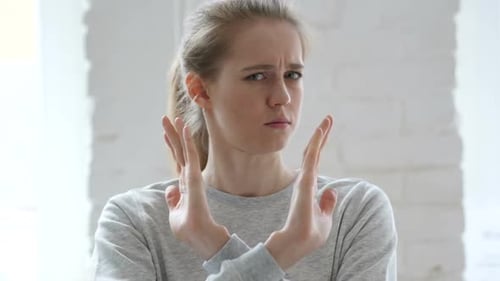 Woman with Blonde Hair Gesturing Stop Indoors