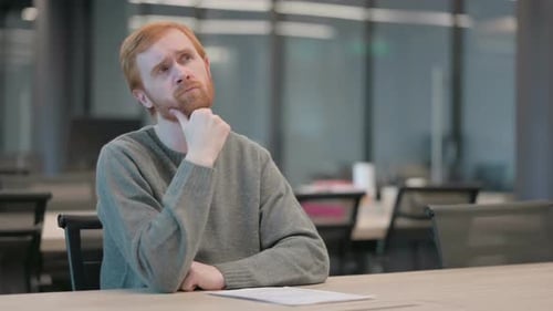 Pensive Young Man Thinking While Sitting in Office