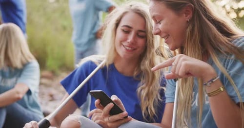 Mid adults volunteering and women laughing during river clean-up day
