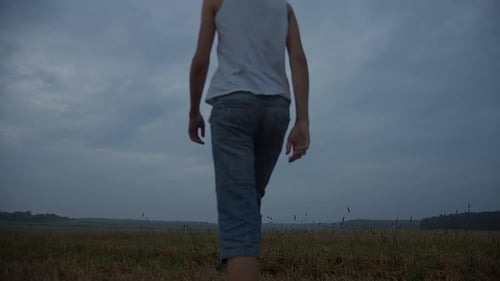 Boy in a Hat Raises Hands To the Sky in the Field