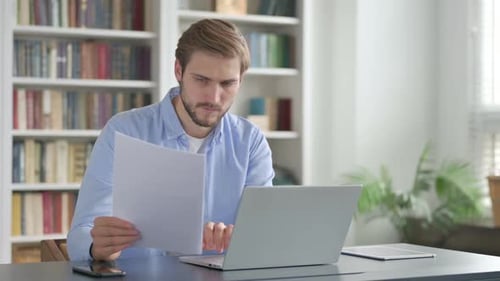 Young Adult Working at Desk With Laptop