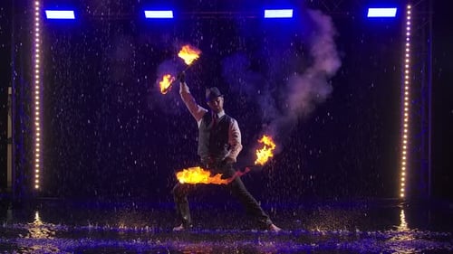 Fire Show in the Rain in the Studio. Professional Artist Performs a Variety of Fire Facilities