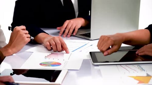Businessmen and women analyze paperwork talk work together gather at briefing table share ideas