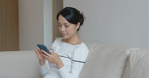 Woman Using Smart Phone Device Indoors at Home
