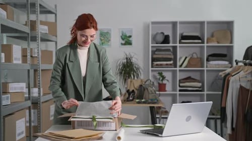 Retail Shop Online Young Business Woman Clothes Packing a Parcel Using a Laptop to Send to Customers