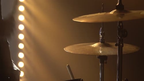 Hands Drummer spielt auf Schlagzeug auf der Bühne in einem dunklen Studio mit Rauch- und Neonbeleuchtung. Dynamisch