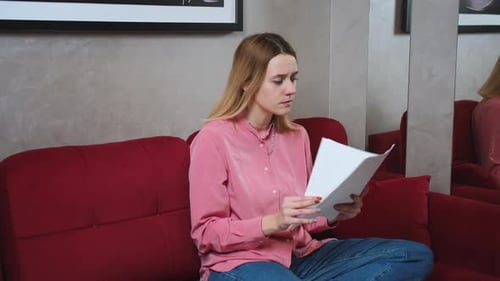 Müde wütende kaukasische Frau arbeitet mit Papieren Laptop auf Sofa zu Hause Frau macht Hausaufgaben auf dem Sofa