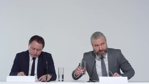 Men at a Table Writing and Taking Notes