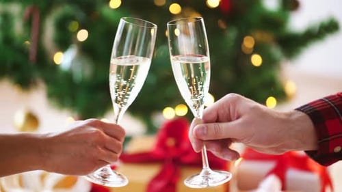 Mãos com taças de vinho espumante no Natal