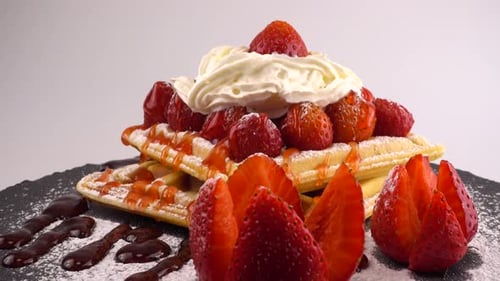 Waffles Topped with Strawberries, Cream, Syrup on Plate