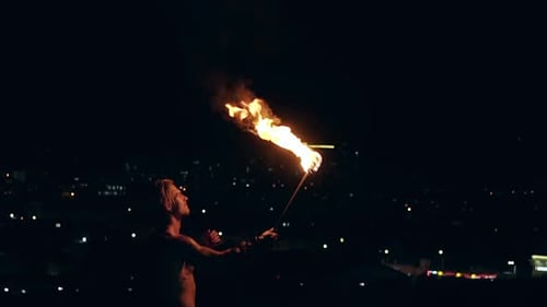 Young Blond Male Breathes Out Large Stream of Fire with Torch on Black Background Slow Motion Shot
