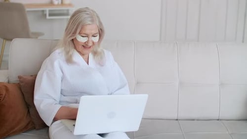 Senior Woman Using Laptop with Beauty Patches