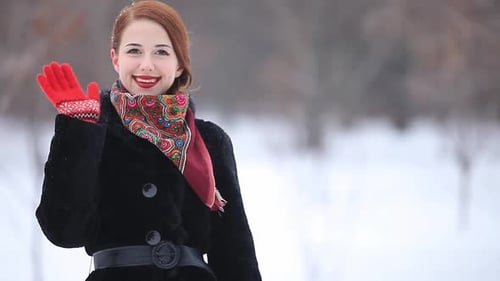 Beautiful redhead woman in the winter park.