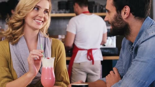 Couple Talking and Smiling Together at Coffee Shop