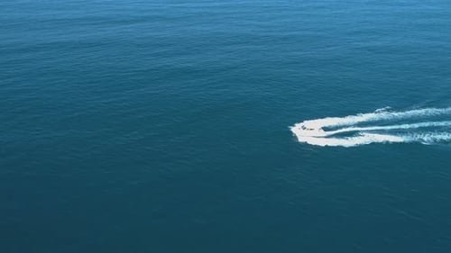Aerial View of Boat Speeding Over the Sea Leaving a Trail of White Foam in Its Wake
