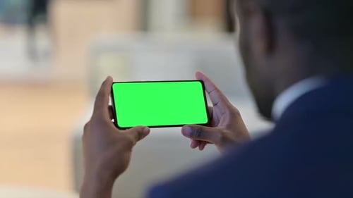 Man Holding Phone with Green Screen Horizontally