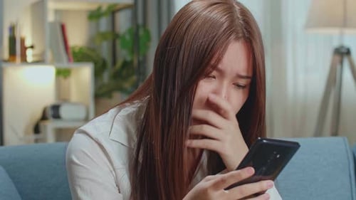 Worried Young Adult Woman Using a Smartphone