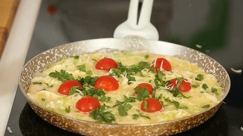 Preparing Omelet with Tomatoes and Fresh Herbs