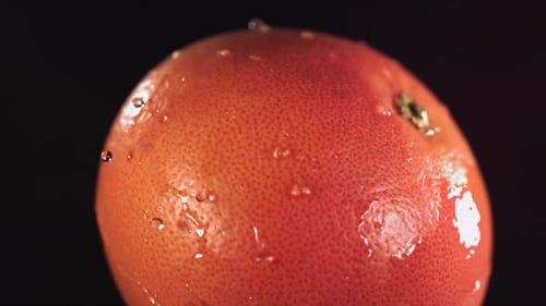 Super Slow Motion Water Drips on Rotating Grapefruit
