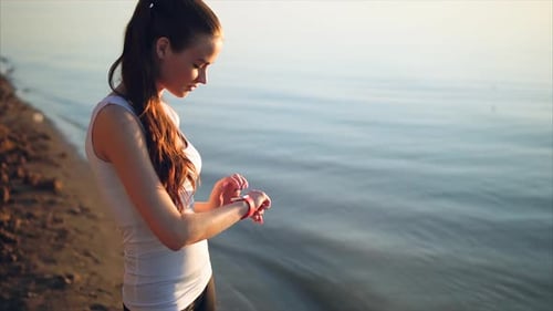 Woman Checks Smartwatch After Lakeside Run
