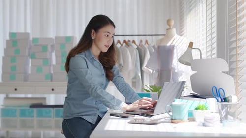 Woman Typing at Desk in Bright Indoor Workspace