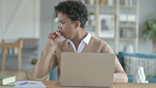 Young Adult Woman Coughing at Desk in Home Office