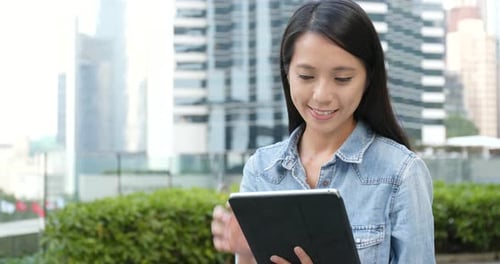 Woman looking at tablet in city