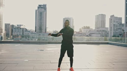 Athletic Man Stretching on City Rooftop