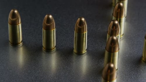 Cinematic rotating shot of bullets on a metallic surface - BULLETS