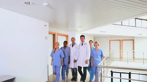 Medical Team Walks Down Bright Hospital Hallway