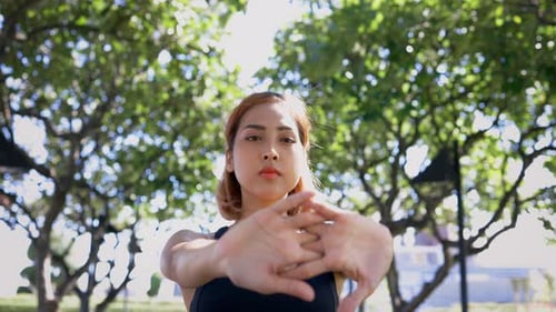 Woman Stretching in Sunny Urban Park