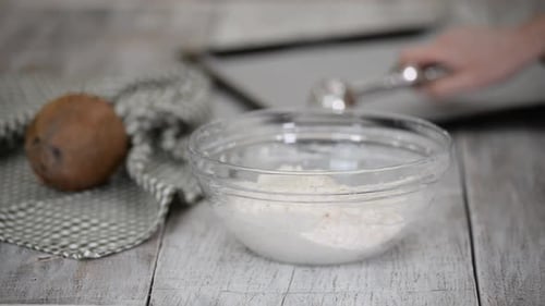 Mujer preparando galletas en la cocina haciendo macarrones de coco