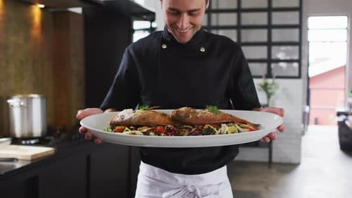 Smiling Chef Presenting Plate of Roasted Fish