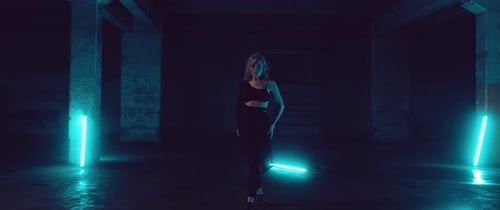 Female Dancer in a dark Parking Lot with Neon Lights