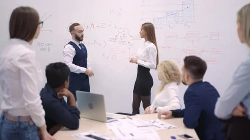 Team Brainstorms Strategy Near Whiteboard in Meeting