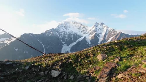 Arrastre postes de ascensor en pendiente desnuda contra el pico nevado del Elbrus