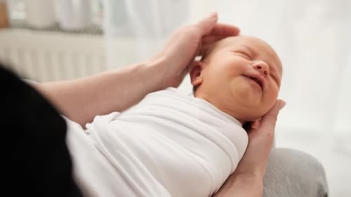 Comforting Newborn in Blanket Held Gently