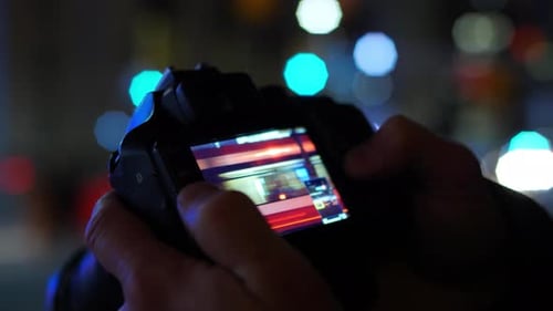 Hands Holding Camera at Night