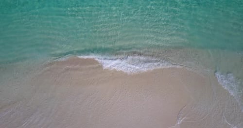 Tropical flying tourism shot of a paradise sunny white sand beach and aqua turquoise water backgroun