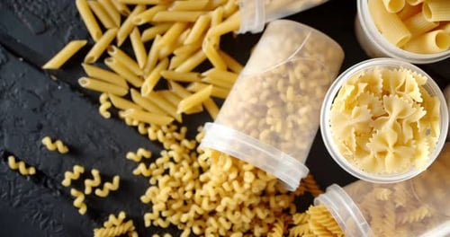 Various Types of Uncooked Pasta on Dark Table