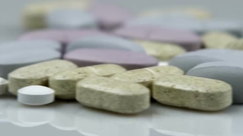 Pills and Tablets Rotating on White Surface