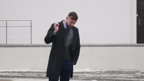 Ein Mann im Business-Anzug wirft eine Zigarette auf den Boden