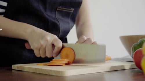 Slicing Carrots on Wooden Cutting Board Close-Up