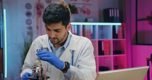 Young Doctor Uses Microscope in Modern Lab