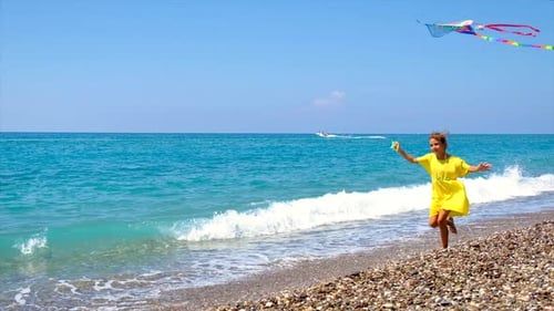 Girl Runs on Beach Flying Colorful Kite