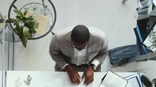 Top Down of Black Businessman Taking a Break while Working on Computer