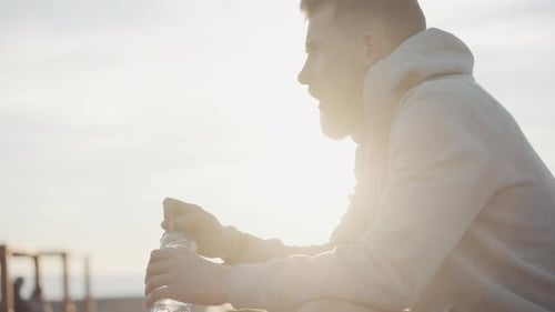 Adult Man Is Sipping Water After Training in Evening in Summer