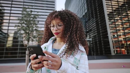 Woman Uses Smart Phone in City Environment